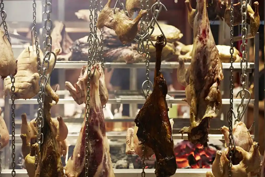 A selection of meats hanging from a chain, showcasing the offerings of temper, a London steakhouse and smokehouse.
