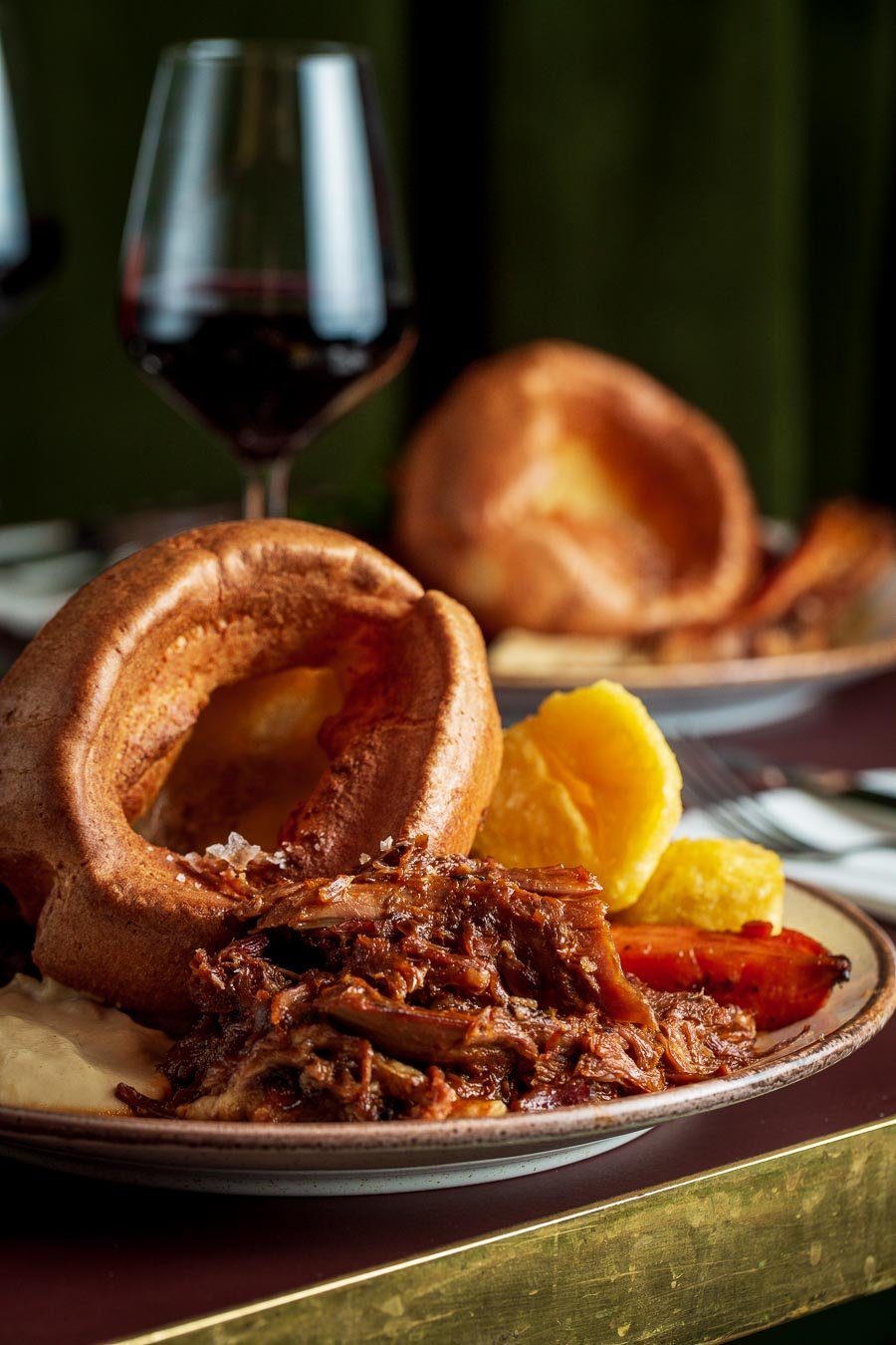 A serving of roast beef with crispy potatoes arranged on a white plate