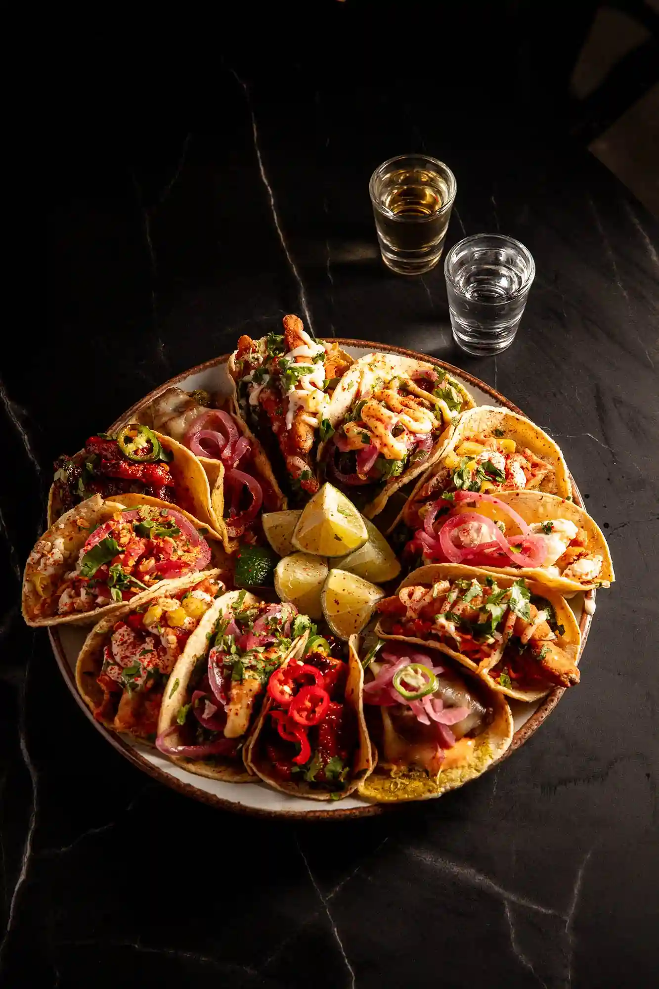 Tacos served on a plate with a glass of water on a table at temper, a London steakhouse known for its barbecue.